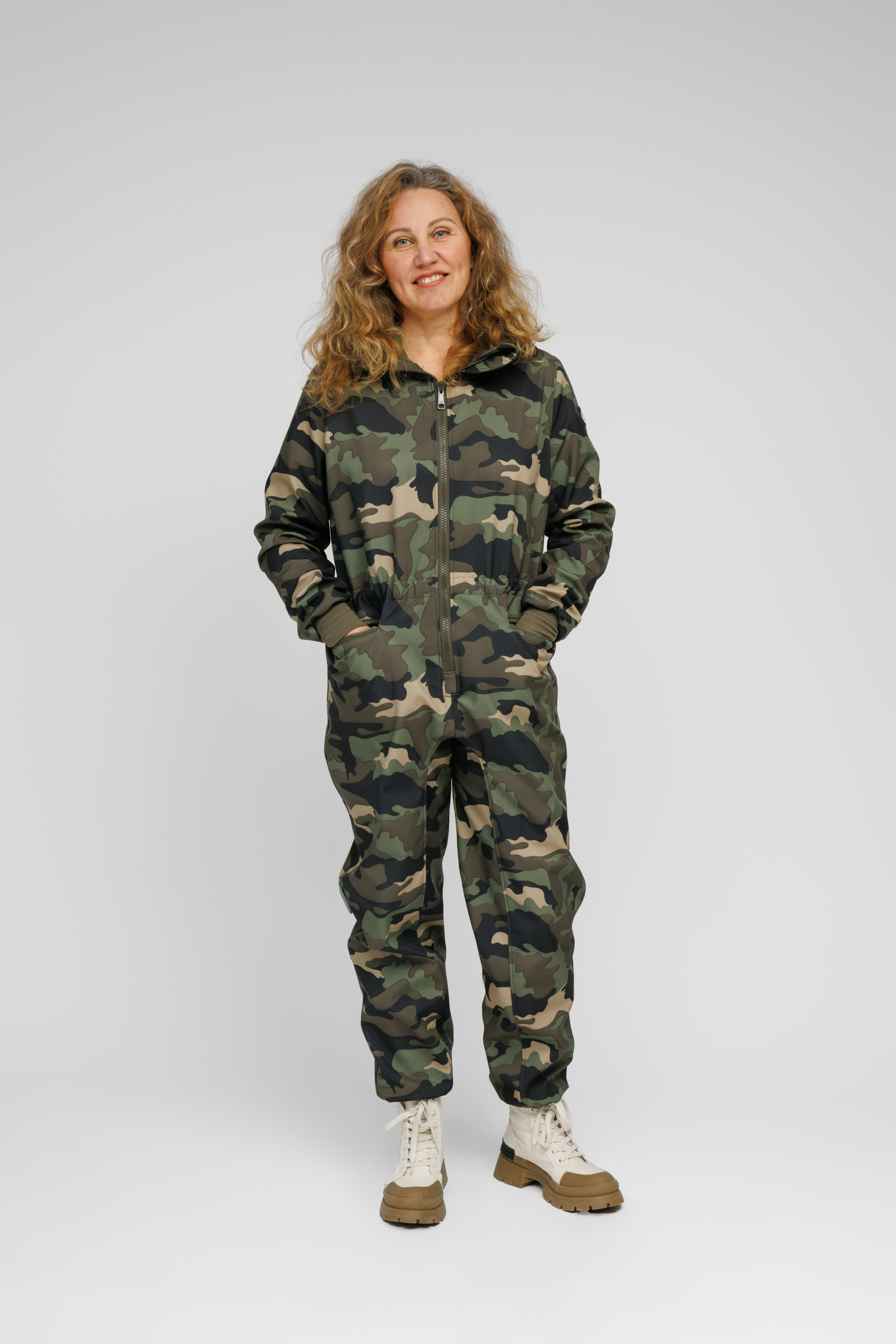 Susanna on tumerohelise militaarmustriga softshell kombekas täiskasvanutele. Ilmastikukindel, kapuutsi ning mitmete taskutega.